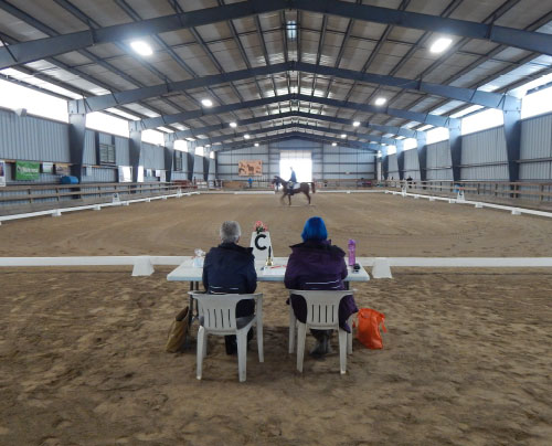 dressage test ongoing in indoor arena